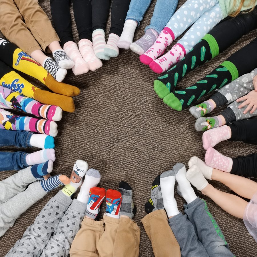 Circle of children's colorful socked feet at ABCD Daycare